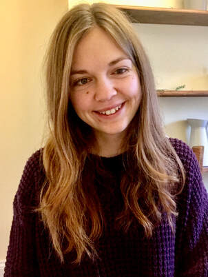 Photo of Beth - a woman in her twenties with long, dark blond hair and smiling at the camera. 